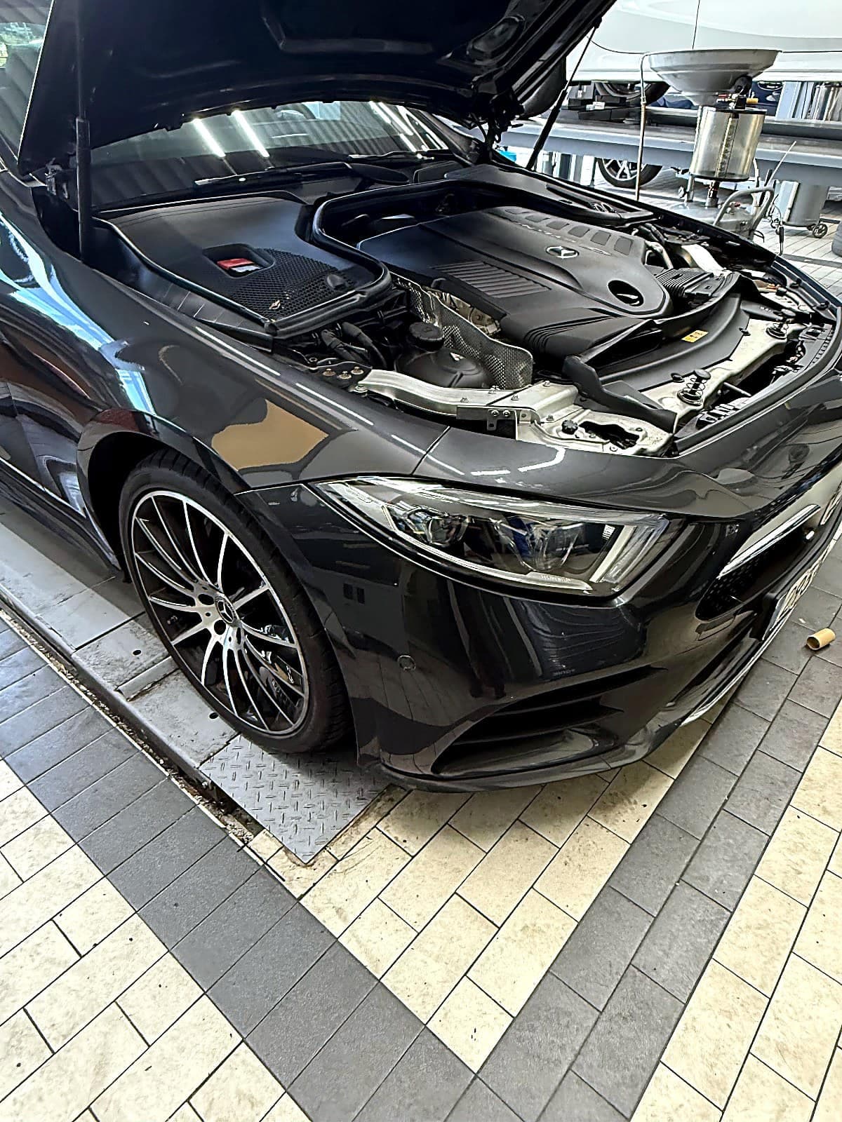 보닛을 열고 리프트 위에 올라온 검은색 벤츠 CLS450 C257